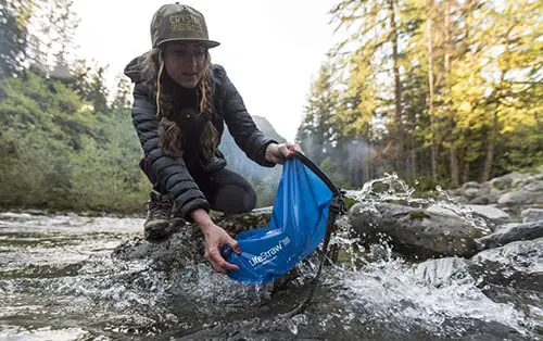 Woman using camping water filter